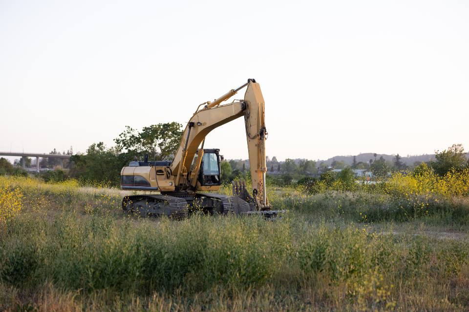 Excavator parked in a dry Kern County field